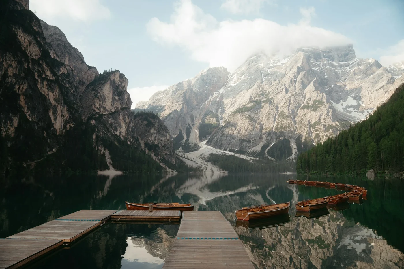 Lago di Braies reflecting Dolomite peaks with wooden boats and dock