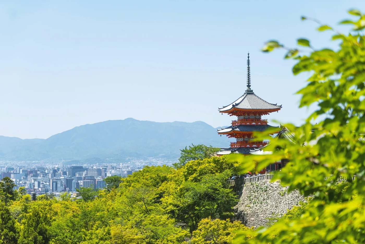 Pagoda at Kiyomizu-dera above Kyoto with green trees and blue sky