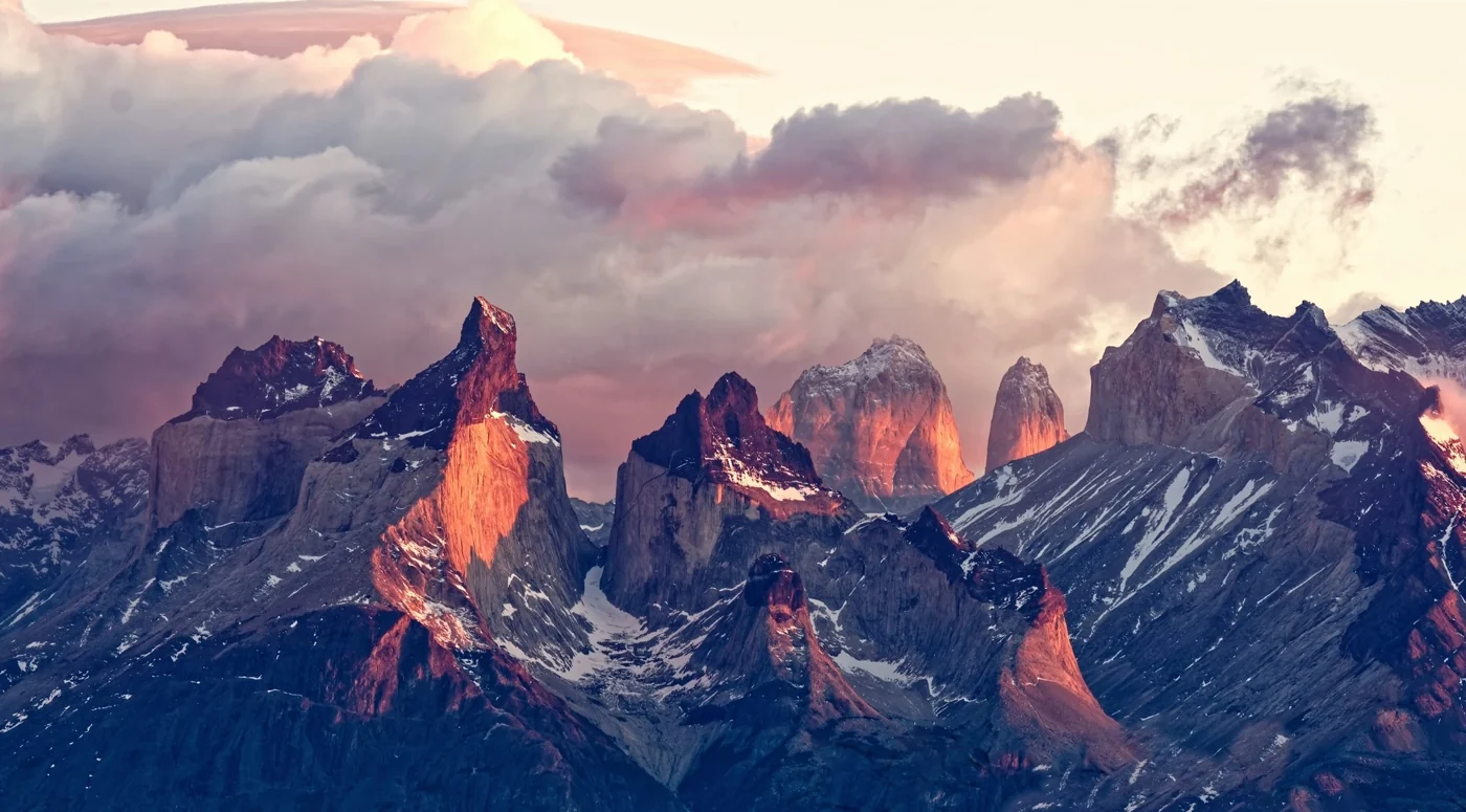 Torres del Paine peaks illuminated in pink and orange sunrise light